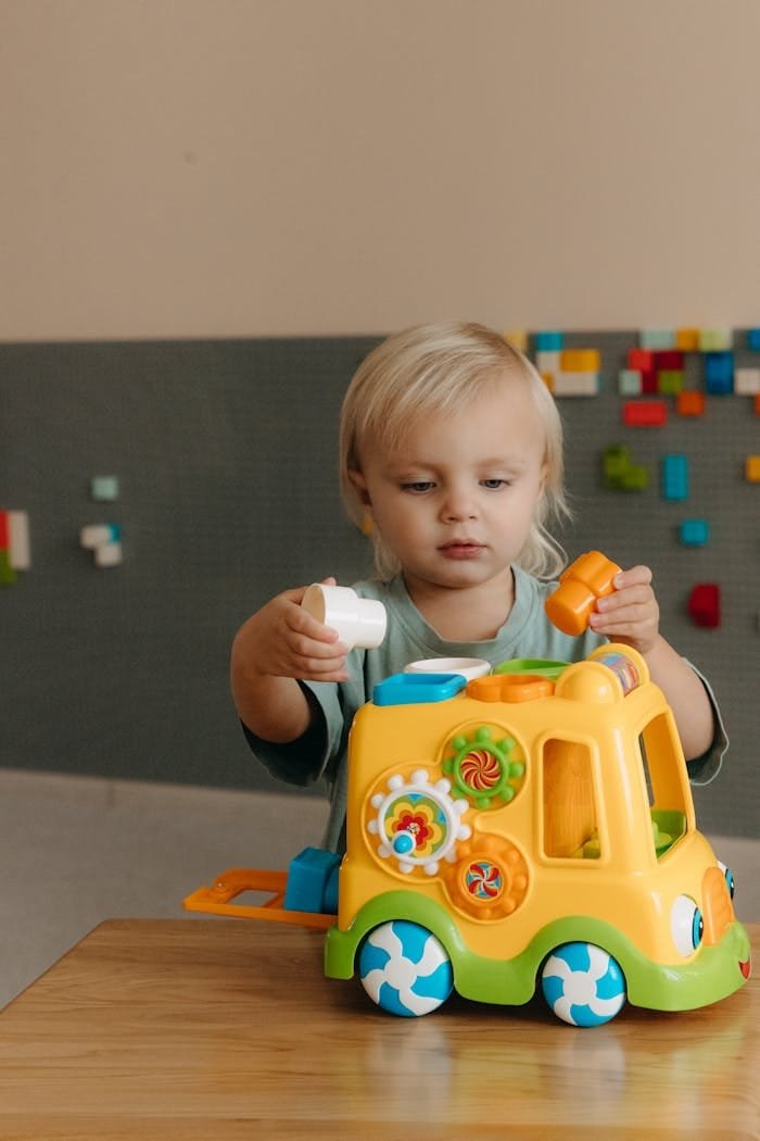 A young child playing indoors with a colorful educational toy. Perfect for family and education concepts.