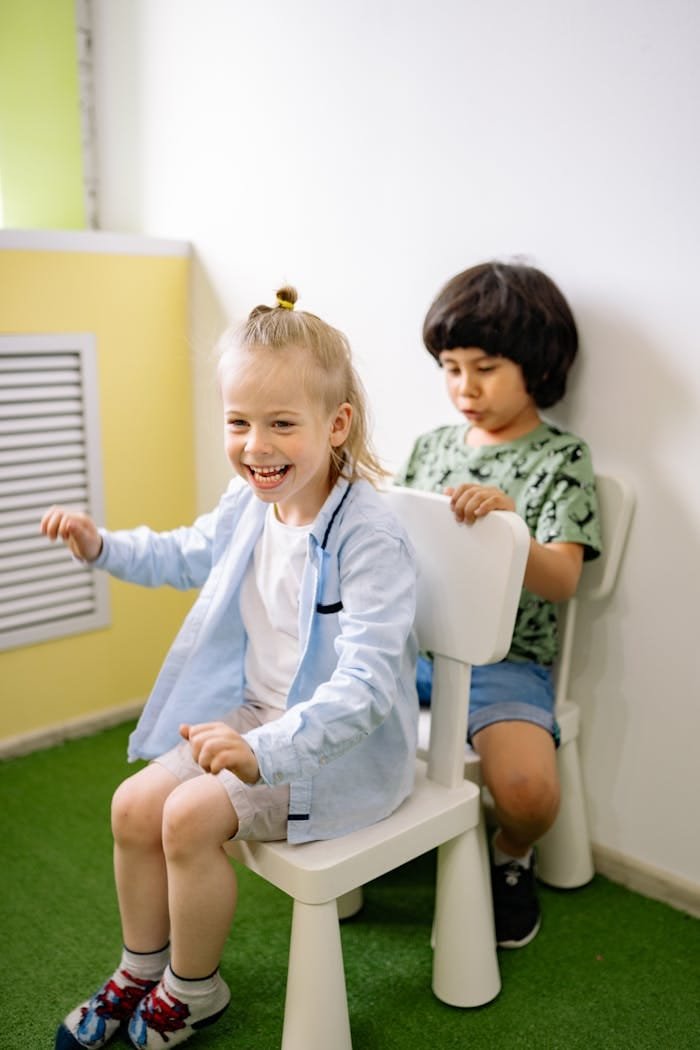 Two children happily play in a colorful preschool setting, enjoying the moment.