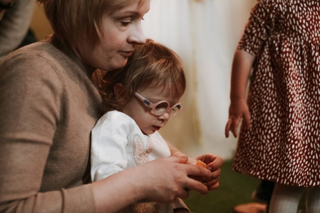 A teacher and a small child working together with modelling clay