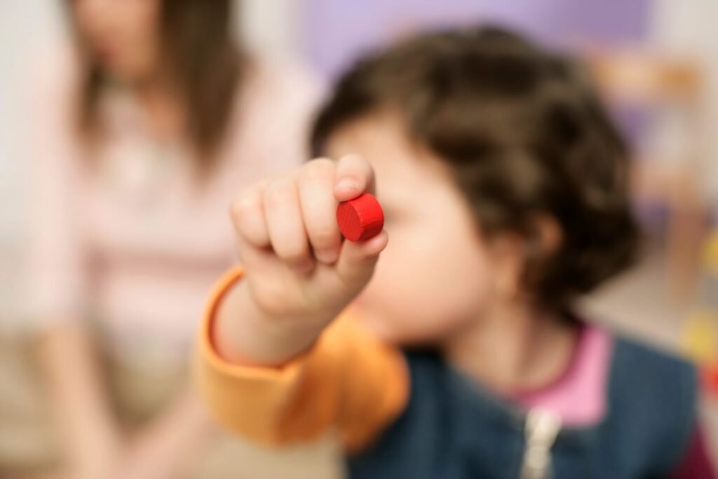A toddler holding a wooden block during sensory play