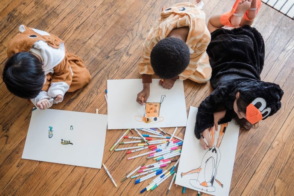 Children drawing and writing at a table, seen from above