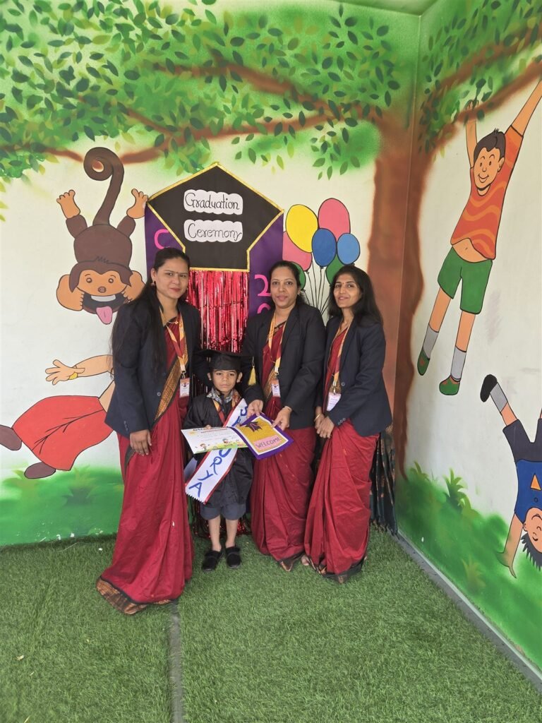 A Tiny Tots Senior KG child in a graduation cap with teachers at the Graduation Ceremony