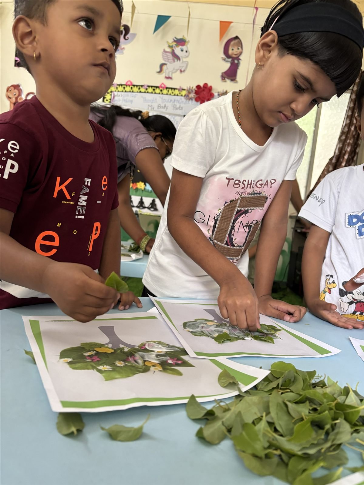 Tiny Tots children sticking real leaves onto a tree picture, building fine motor control